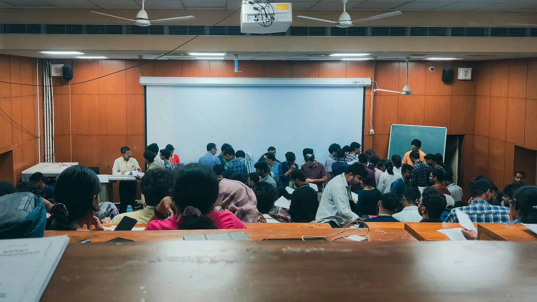 Students working through an admission process in a seminar hall